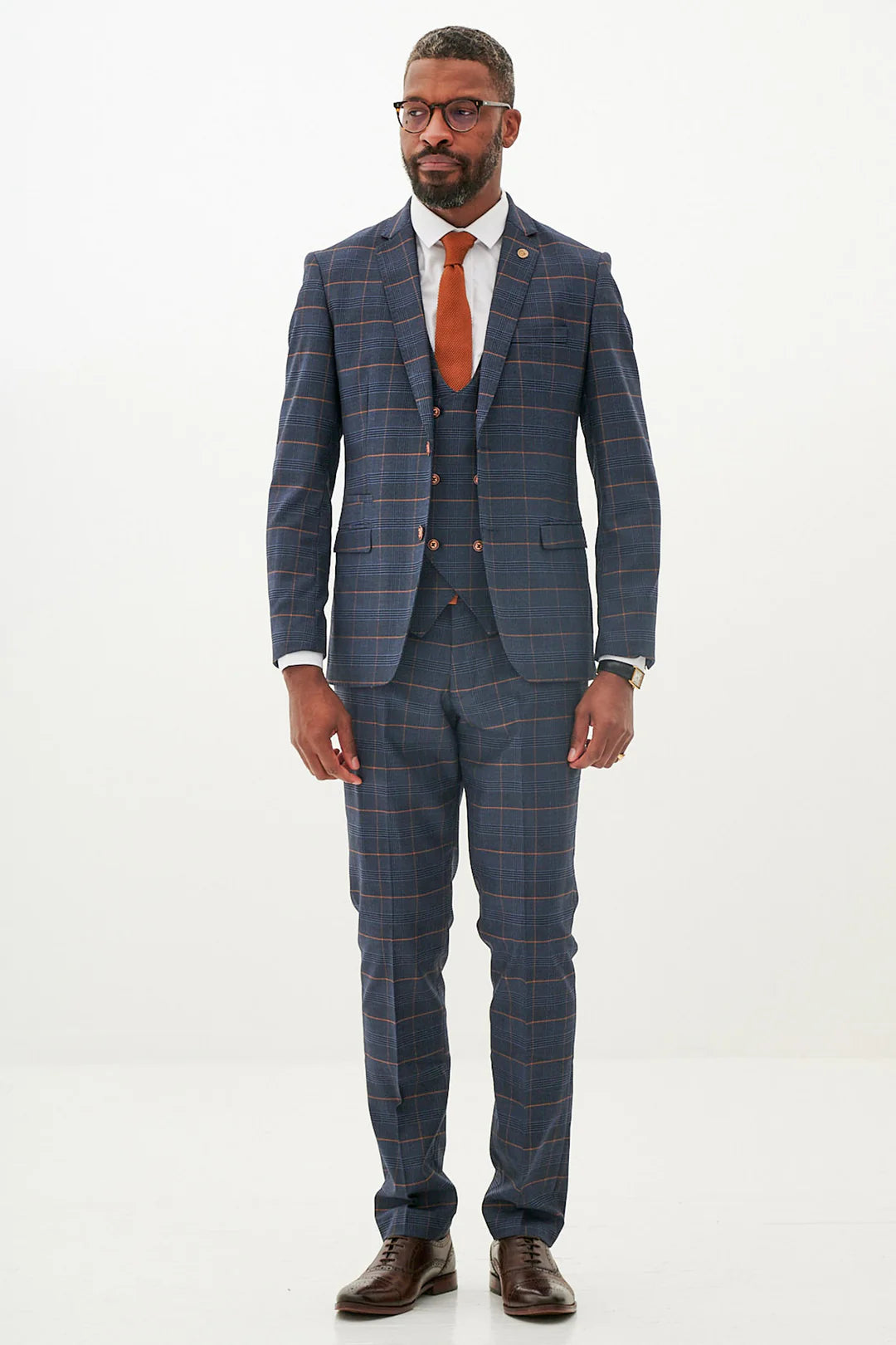 Man wearing a blue checkered suit with a red tie on a white background