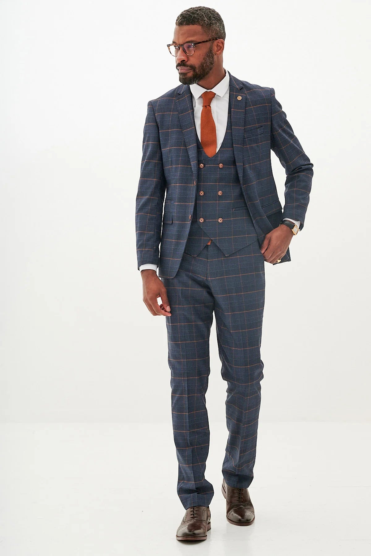 Man wearing a blue checkered suit with a red tie on a white background