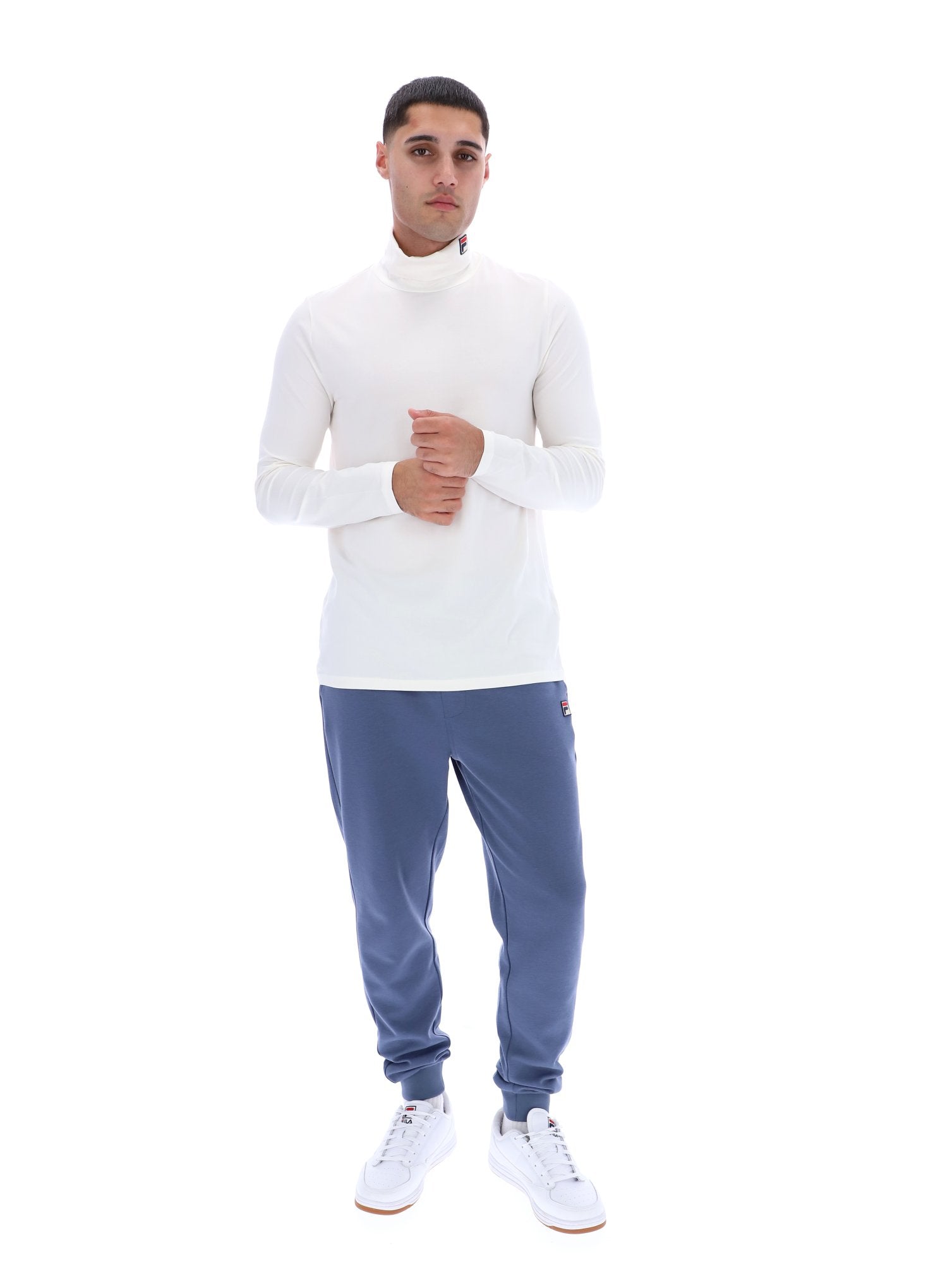 Man wearing a white long-sleeve shirt and blue pants on a white background