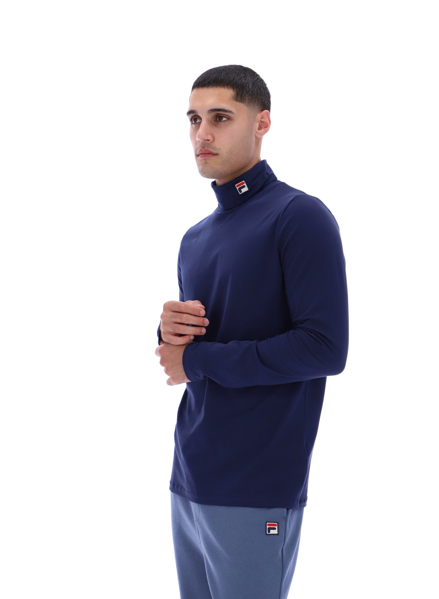 Man wearing a navy blue turtleneck sweater with a visible brand logo on a white background
