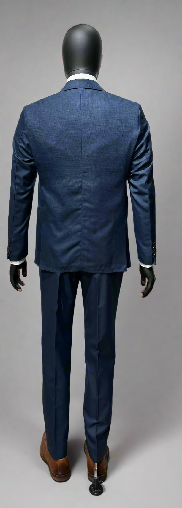 Navy blue suit on a mannequin against a gray background
