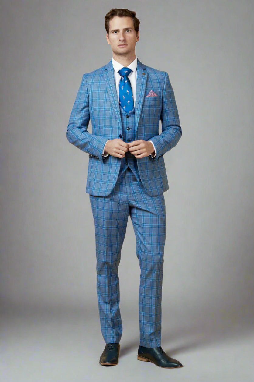 A man wearing a Marc Darcy JOSE sky blue check three-piece suit with a notch lapel, a white shirt, and a blue tie.