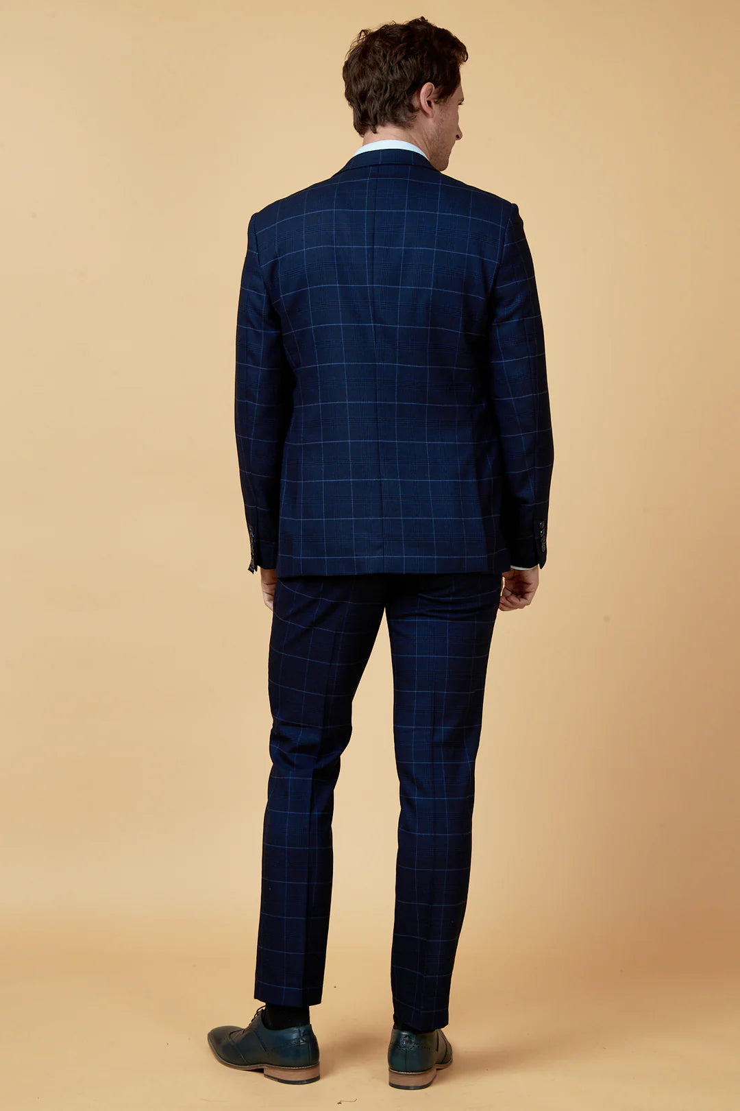 Person wearing a blue checkered suit on a beige background