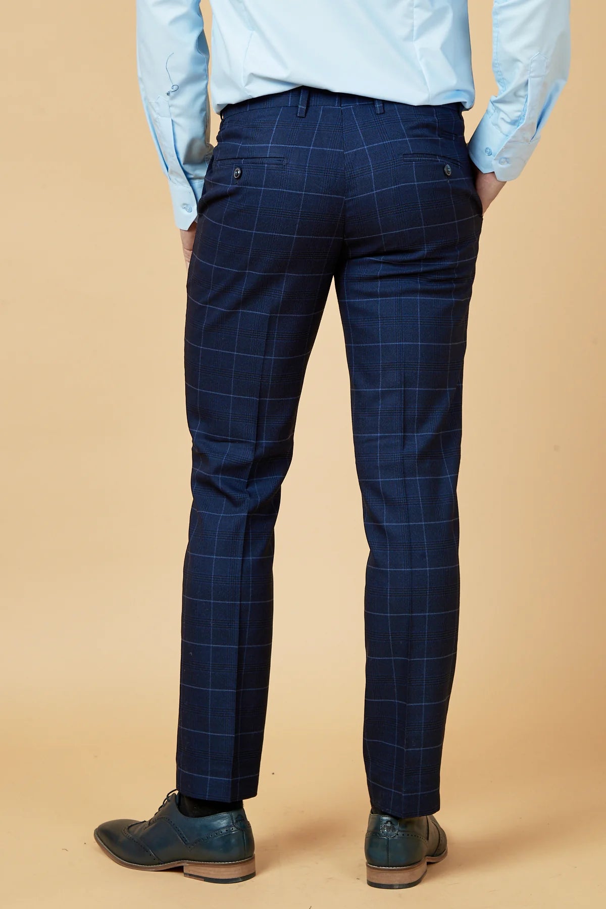 Blue checkered pants worn by a person on a beige background