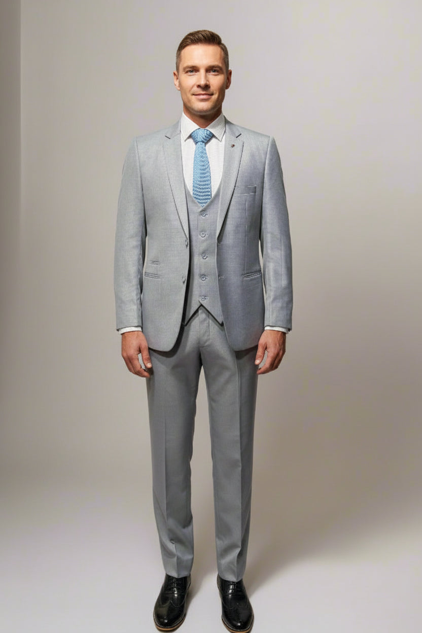 A three-piece suit on a mannequin, featuring a light sky color with a tie and black shoes.