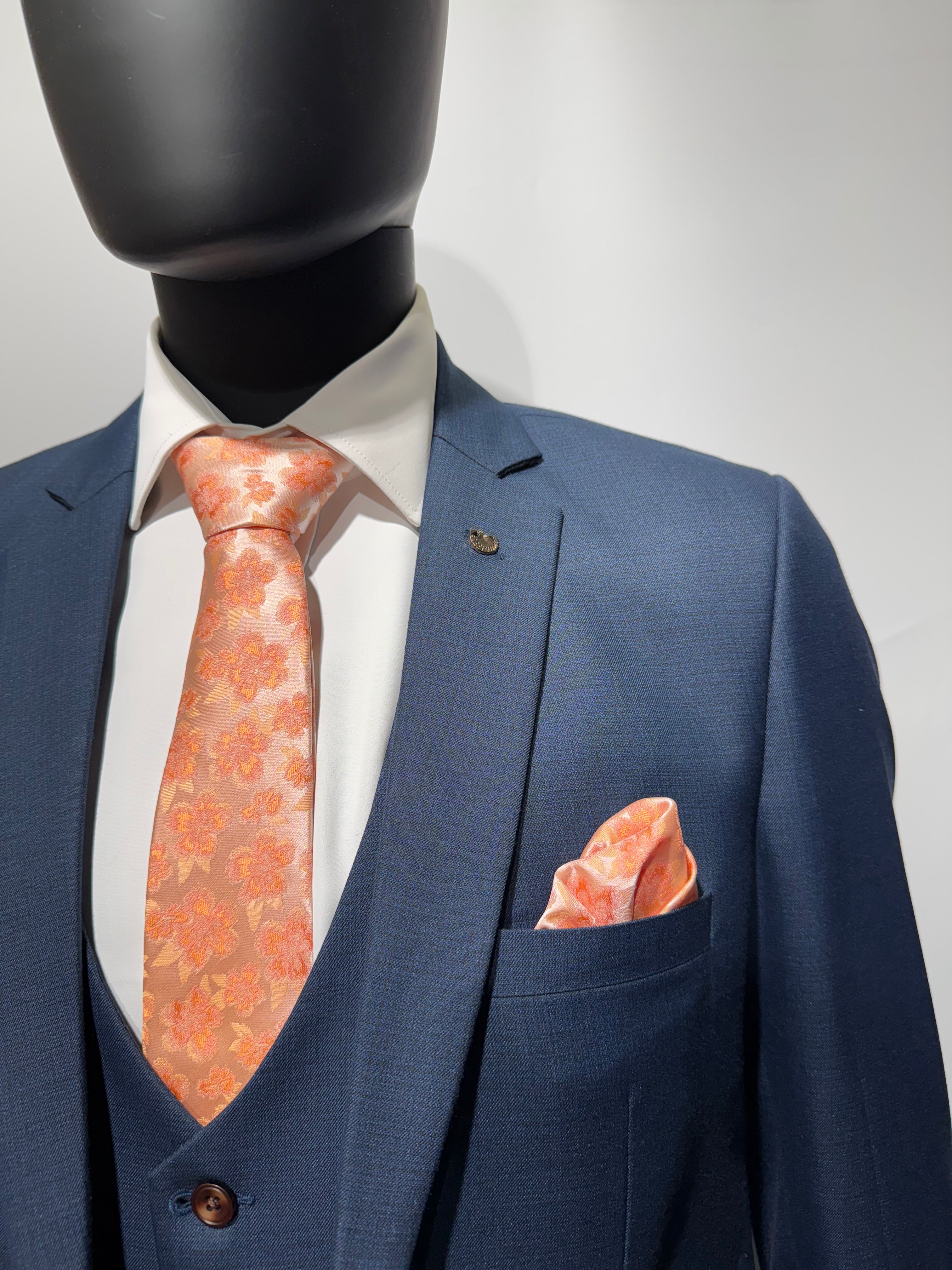 Close-up of a navy blue suit with floral patterned pocket square.