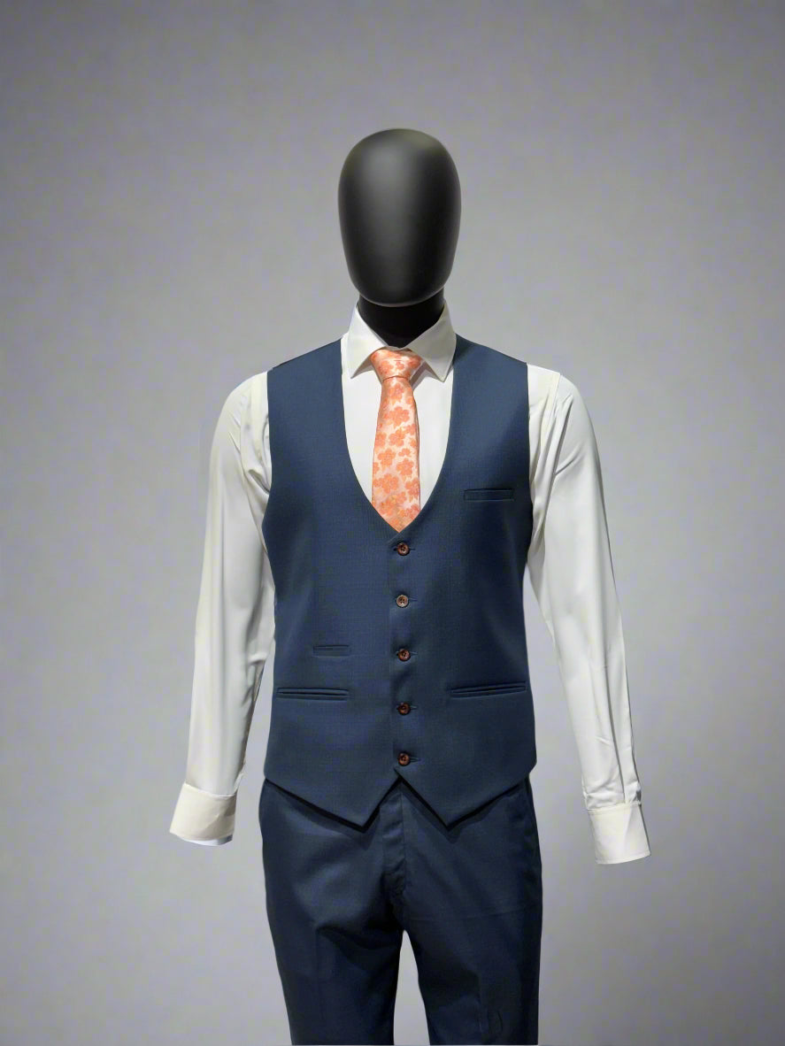 Mannequin wearing a navy suit with a white shirt and patterned tie on a white platform.