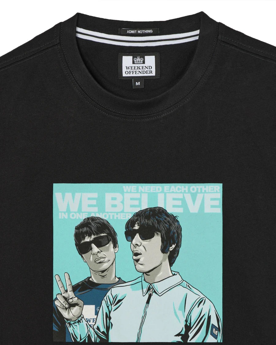 Black t-shirt with graphic design of two people and text 'We Believe' on a white background