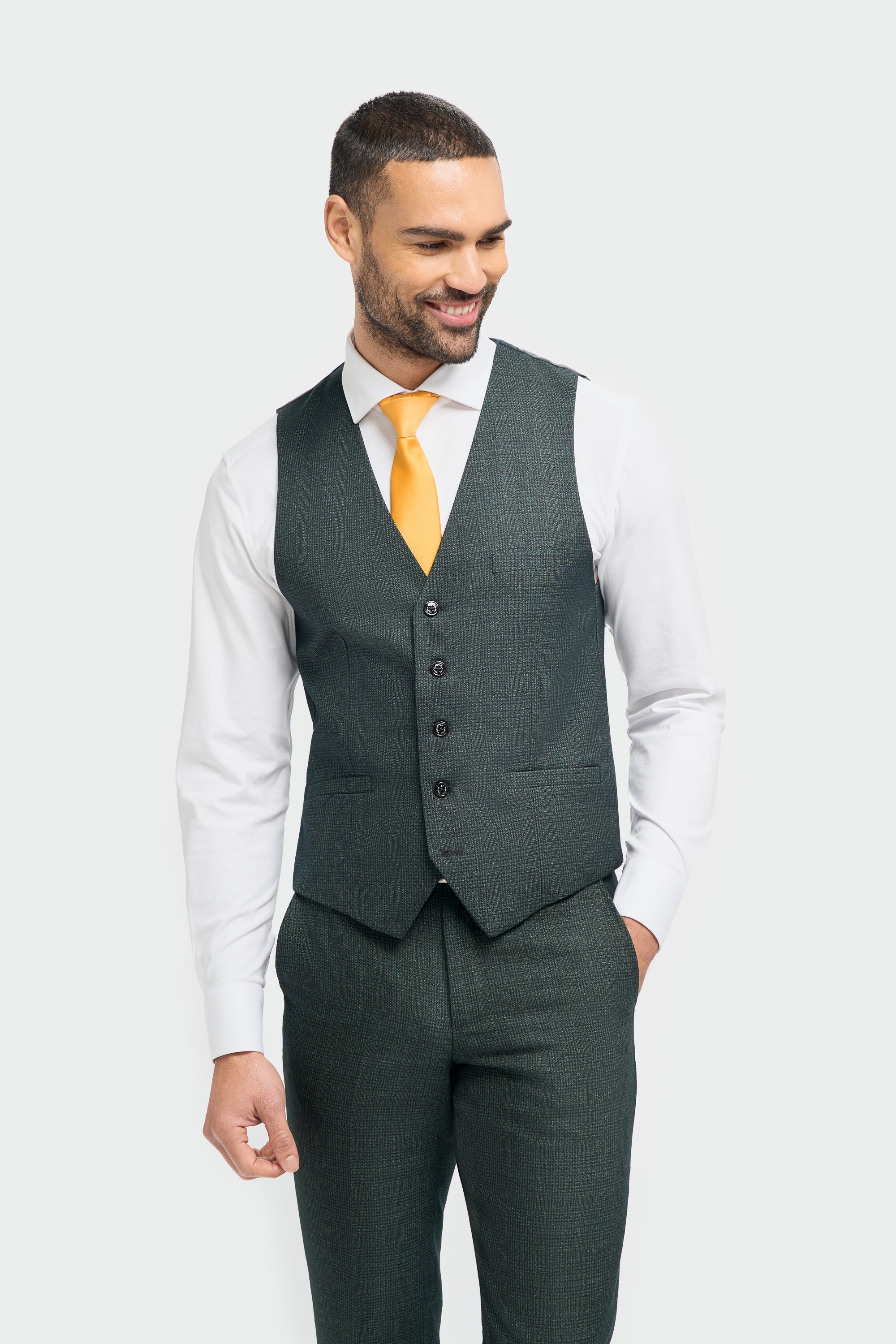 Man wearing a dark green vest and suit on a white background