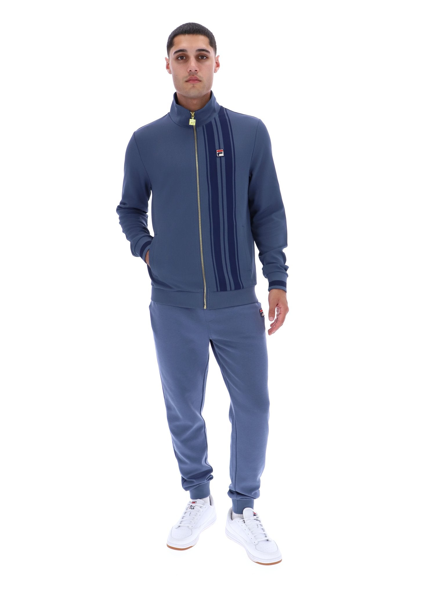 Man wearing a blue tracksuit with a brand logo on a white background