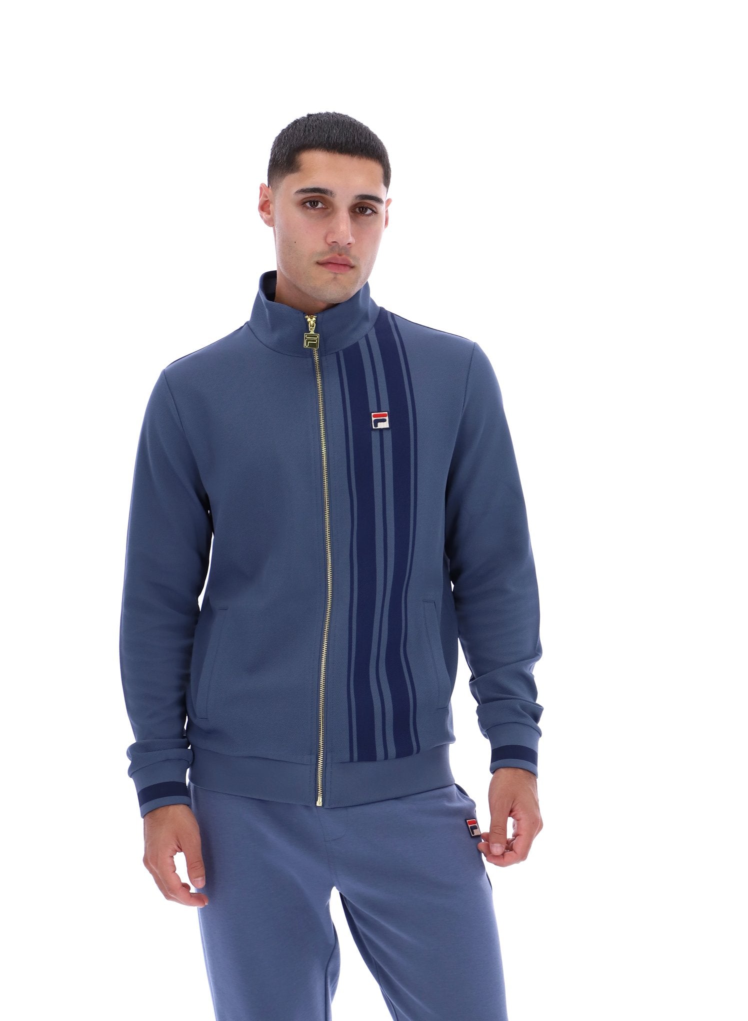 Man wearing a blue tracksuit with a brand logo on a white background