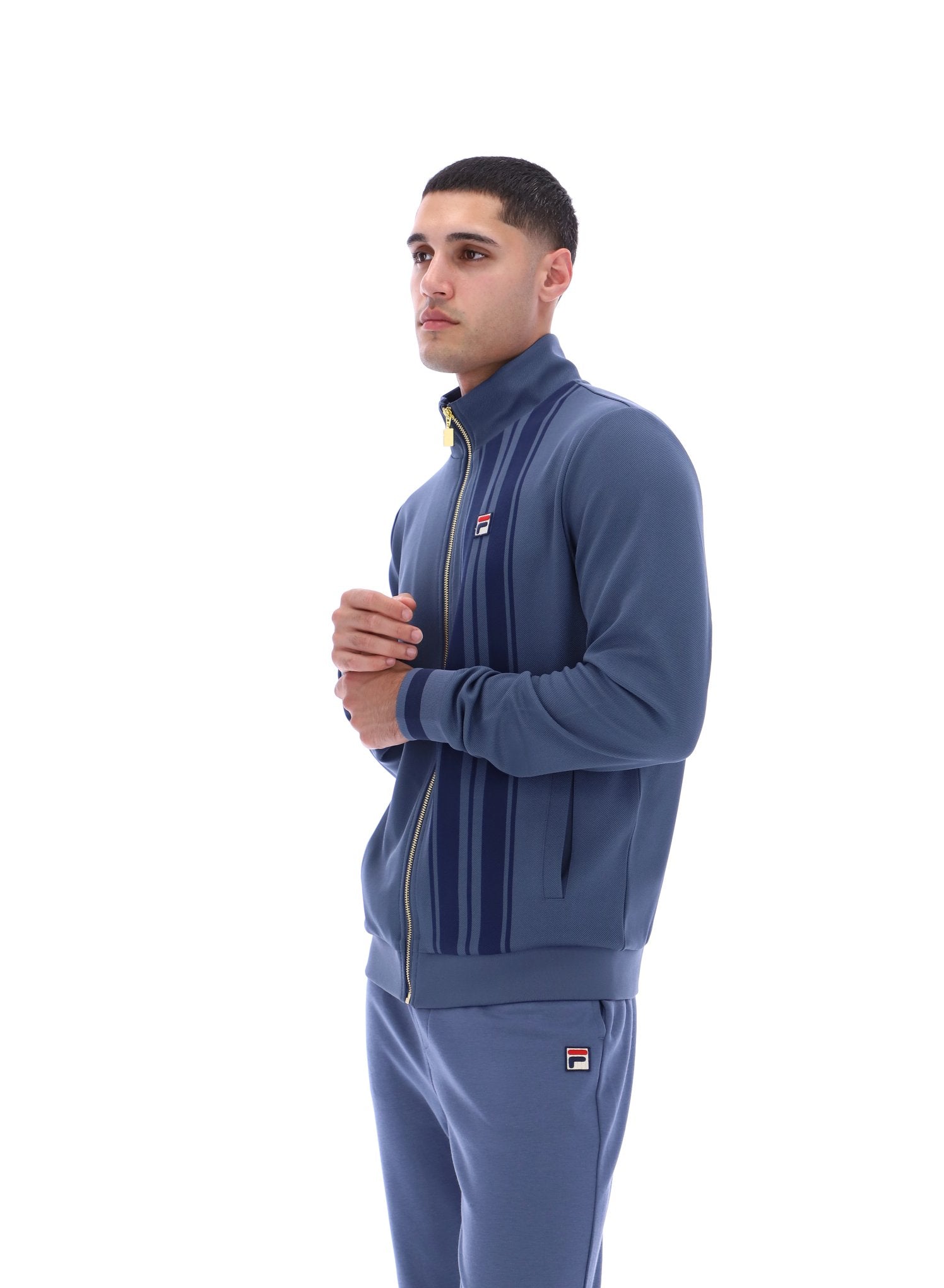 Man wearing a blue tracksuit with a brand logo on a white background