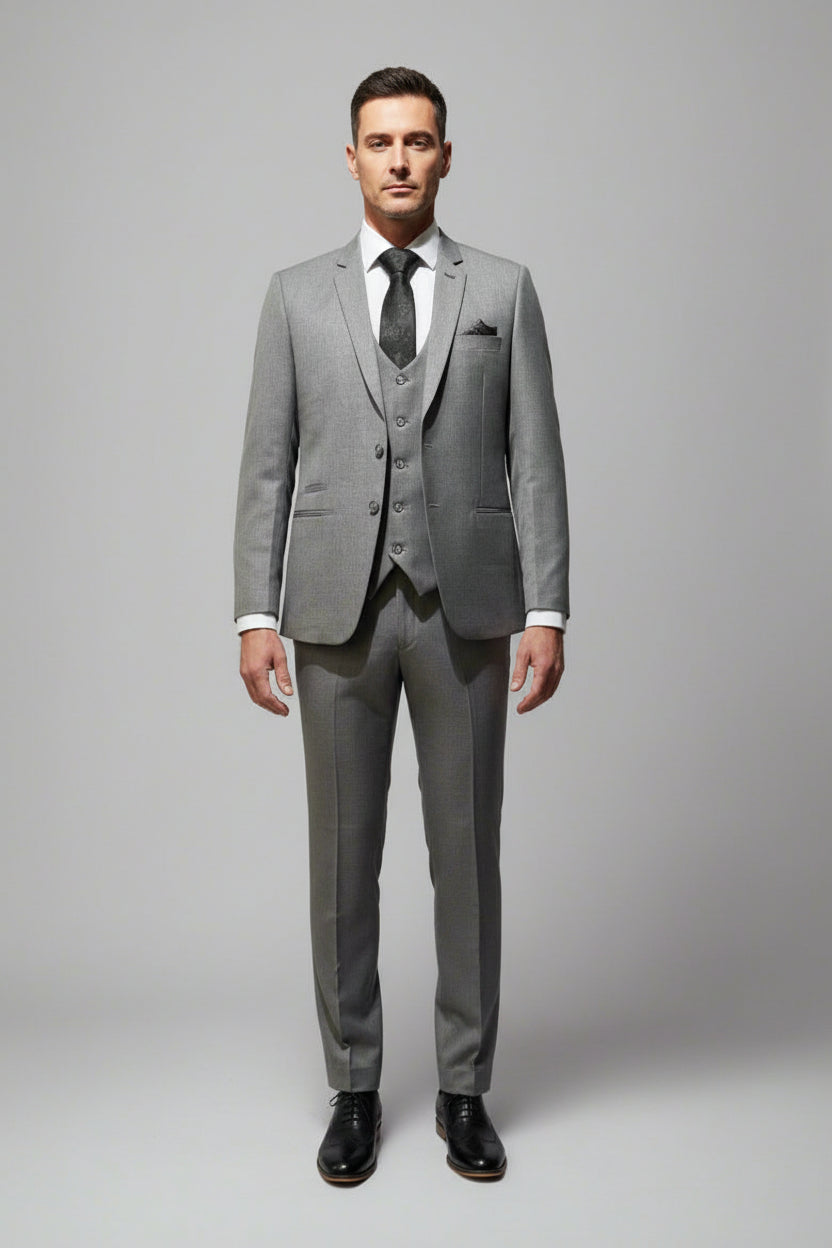 A three-piece dark grey suit on a mannequin, including a jacket, trousers, and a tie.