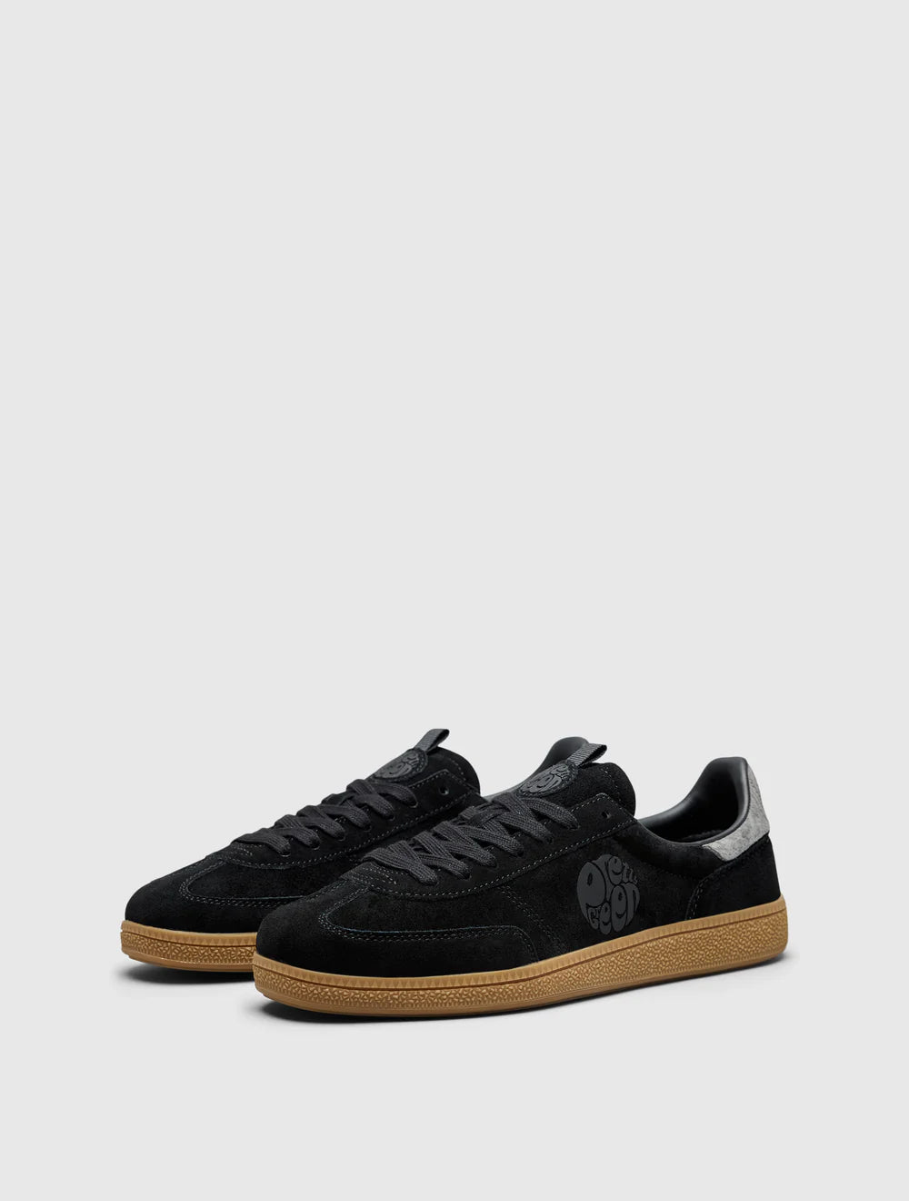 A black Pretty Green trainer with a paisley graphic and logo, featuring a microfibre suede upper, contrast spoiler, and lace closure.