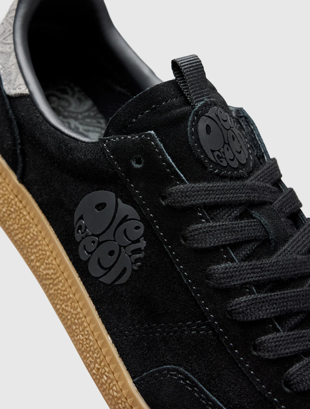 A black Pretty Green trainer with a paisley graphic and logo, featuring a microfibre suede upper, contrast spoiler, and lace closure.