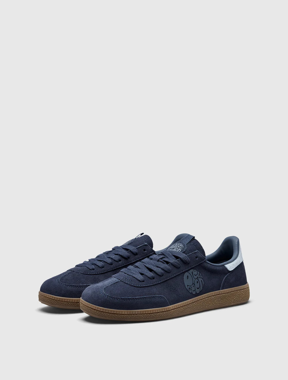 A navy-colored Pretty Green trainer with a suede upper, paisley graphic and logo, and a rubber gum outsole.