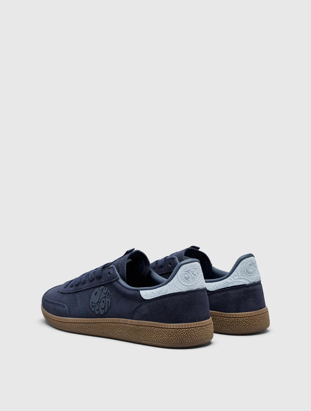 A navy-colored Pretty Green trainer with a suede upper, paisley graphic and logo, and a rubber gum outsole.
