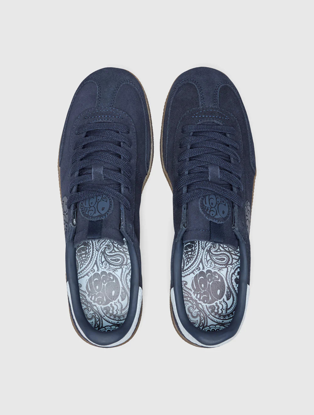 A navy-colored Pretty Green trainer with a suede upper, paisley graphic and logo, and a rubber gum outsole.