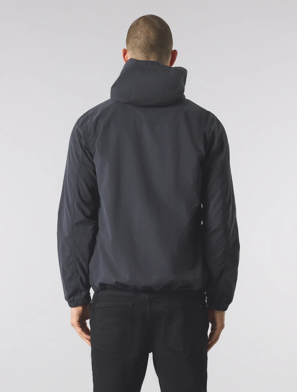 Person wearing a black jacket and pants on a white background