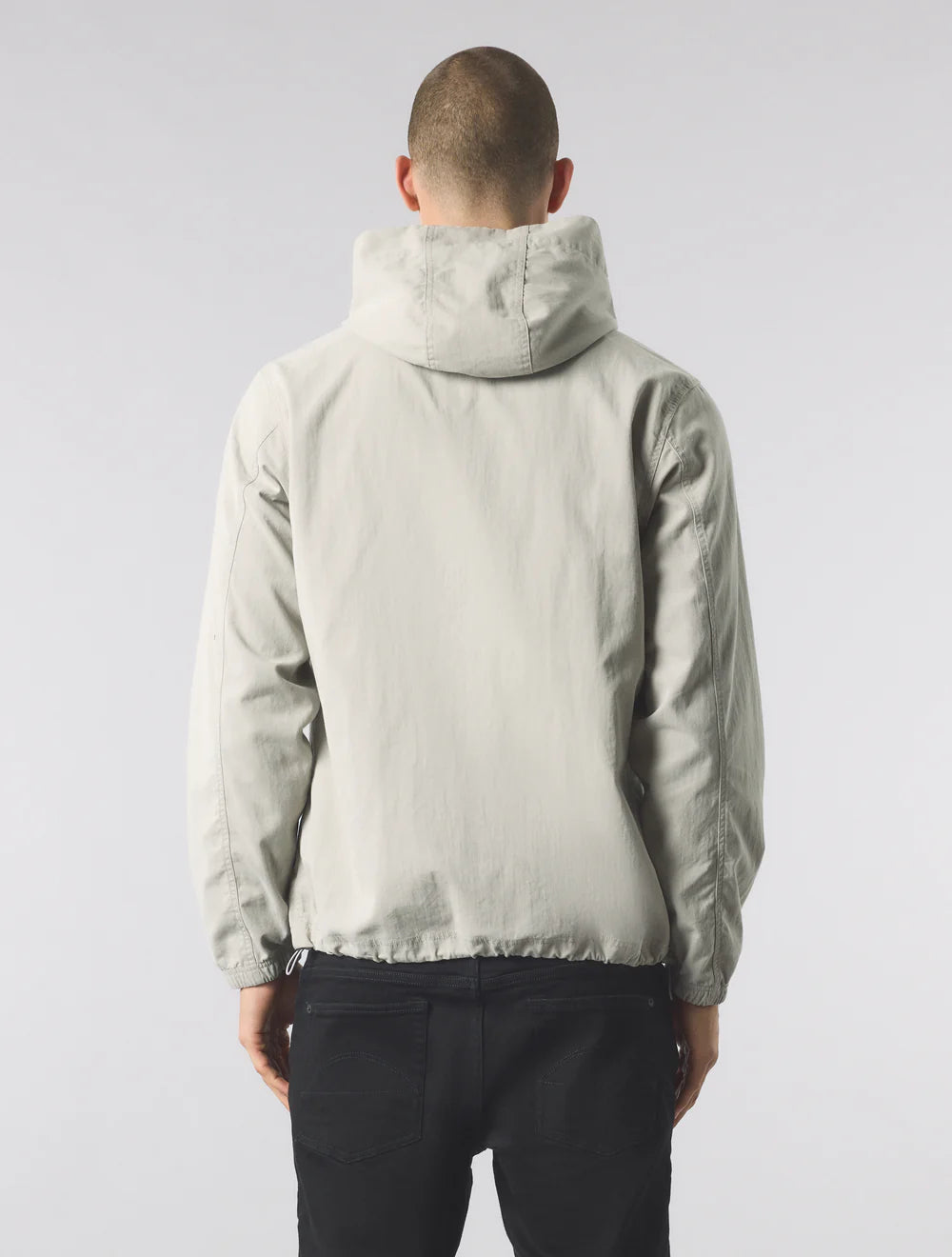 Person wearing a light gray jacket on a white background