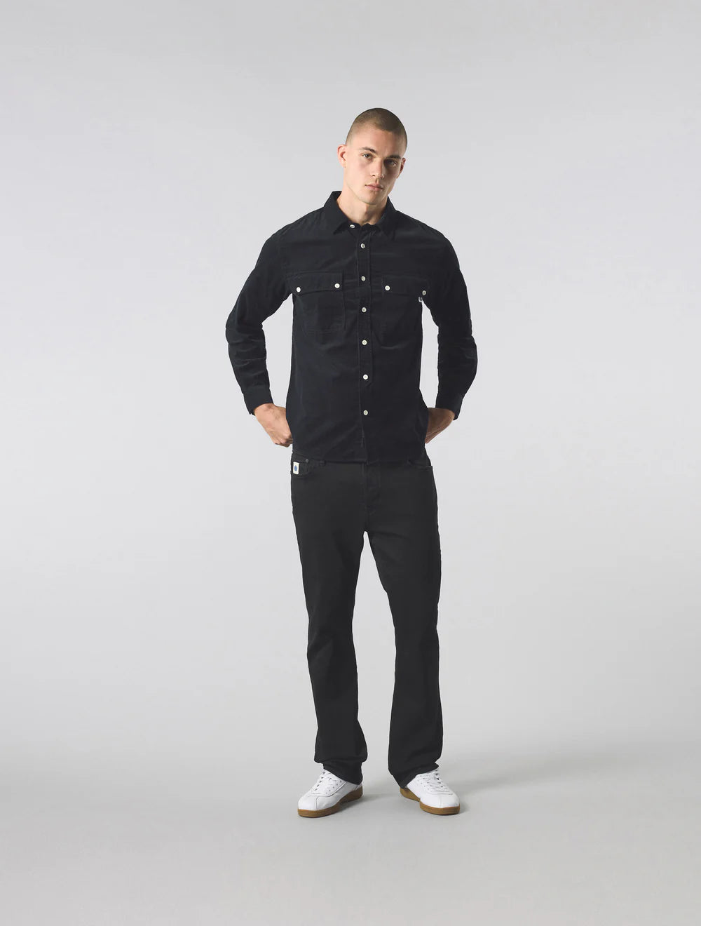 Man wearing a black shirt and jeans on a white background