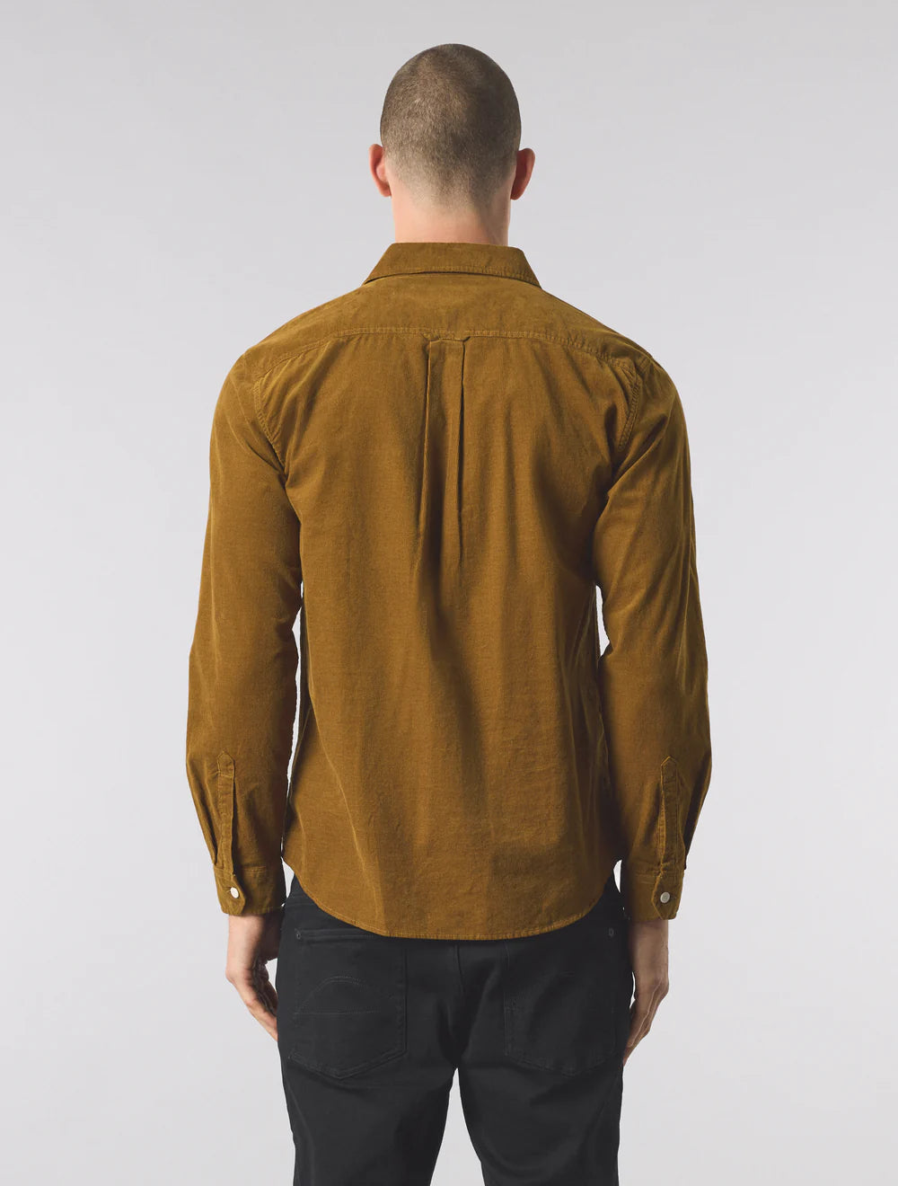 Man wearing a mustard yellow shirt on a white background