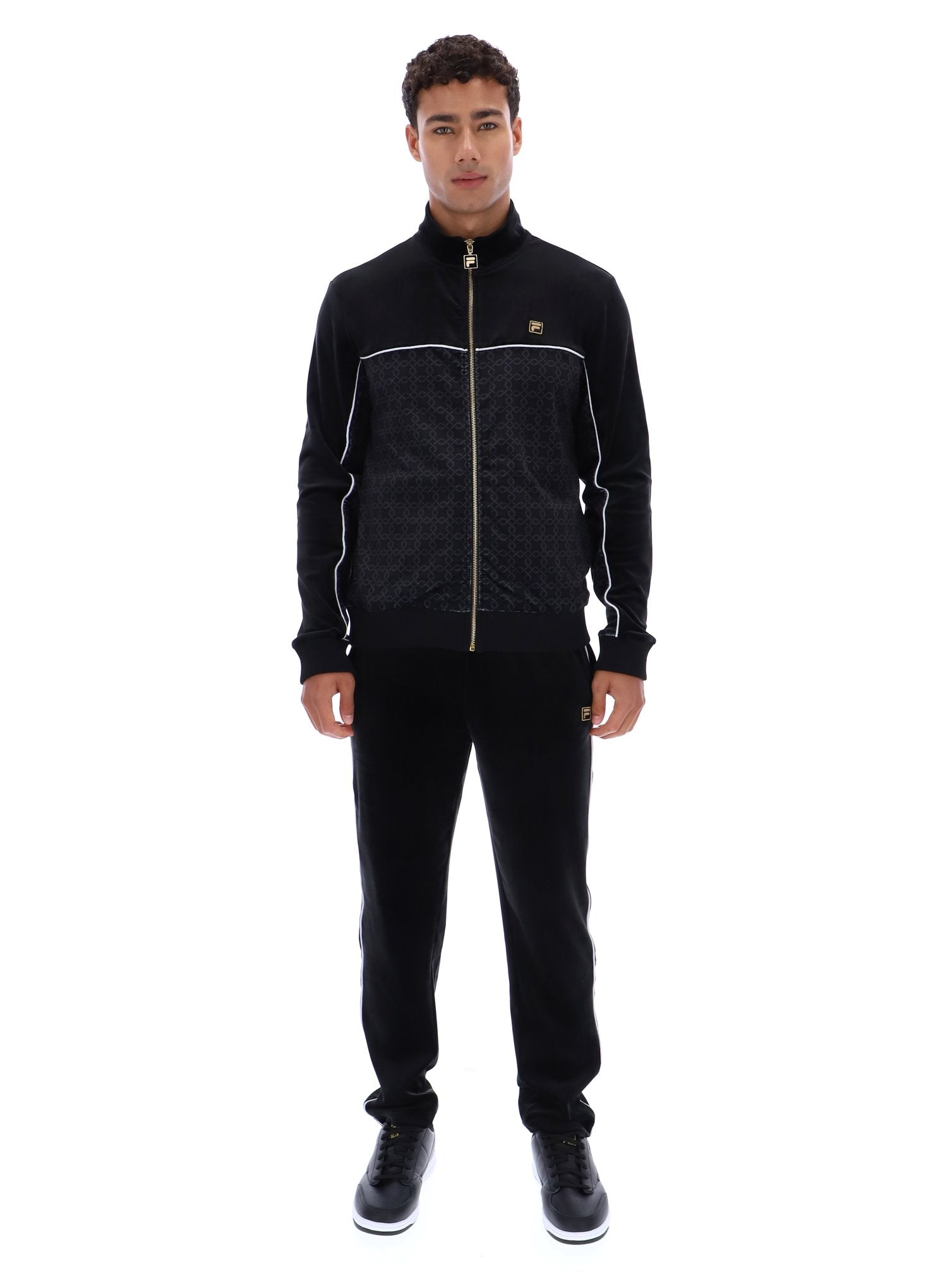 Man wearing a black quilted jacket and pants on a white background