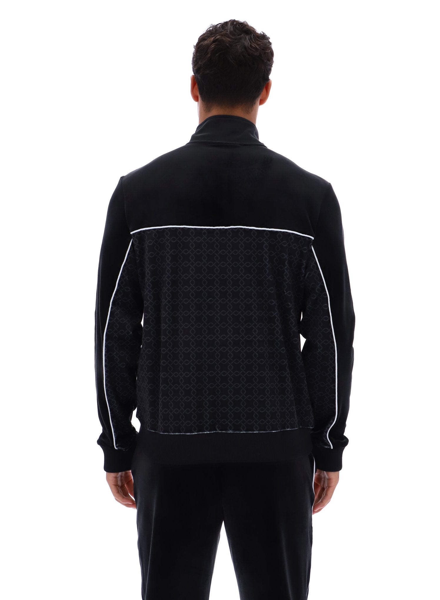 Man wearing a black jacket with geometric pattern on a white background