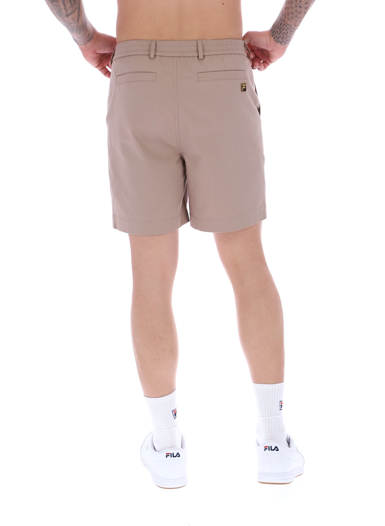 A pair of chino shorts in a neutral color, worn by a model standing against a plain background.
