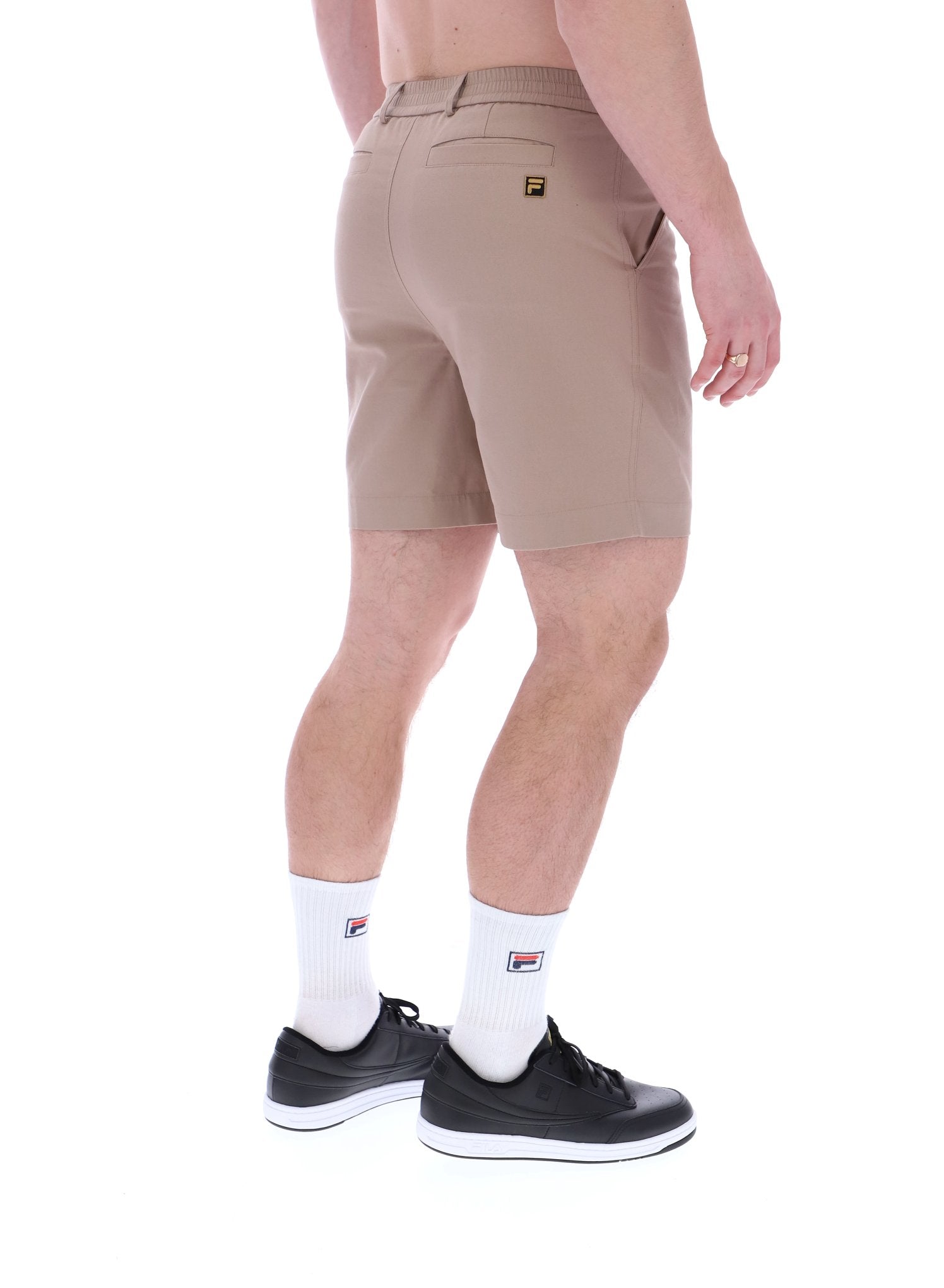 A pair of chino shorts in a neutral color, worn by a model standing against a plain background.