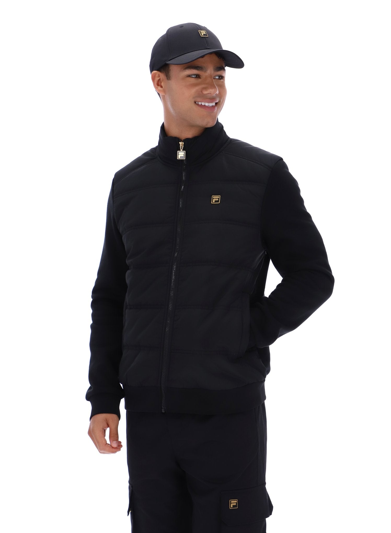 Person wearing a black jacket and pants with a cap on a white background