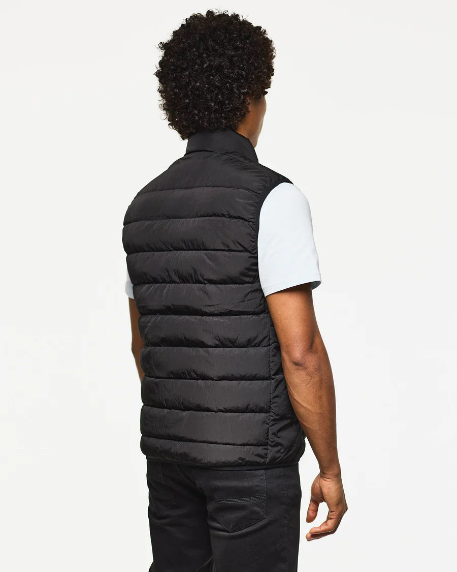 Person wearing a black puffer vest on a white background