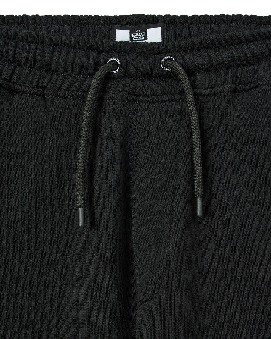 Close-up of black pants with drawstring and brand label.