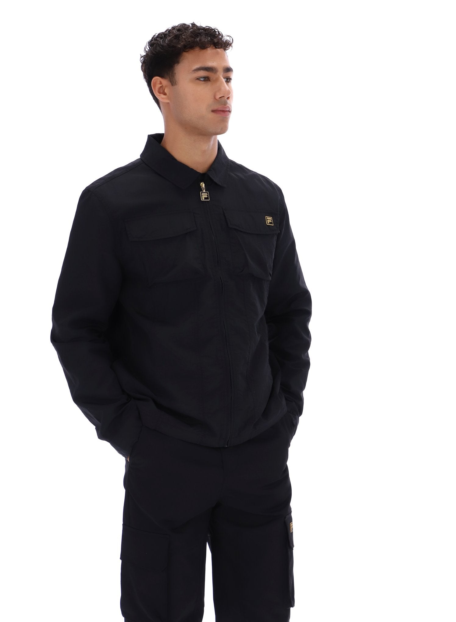 Person wearing a black outfit with a brand logo on a white background