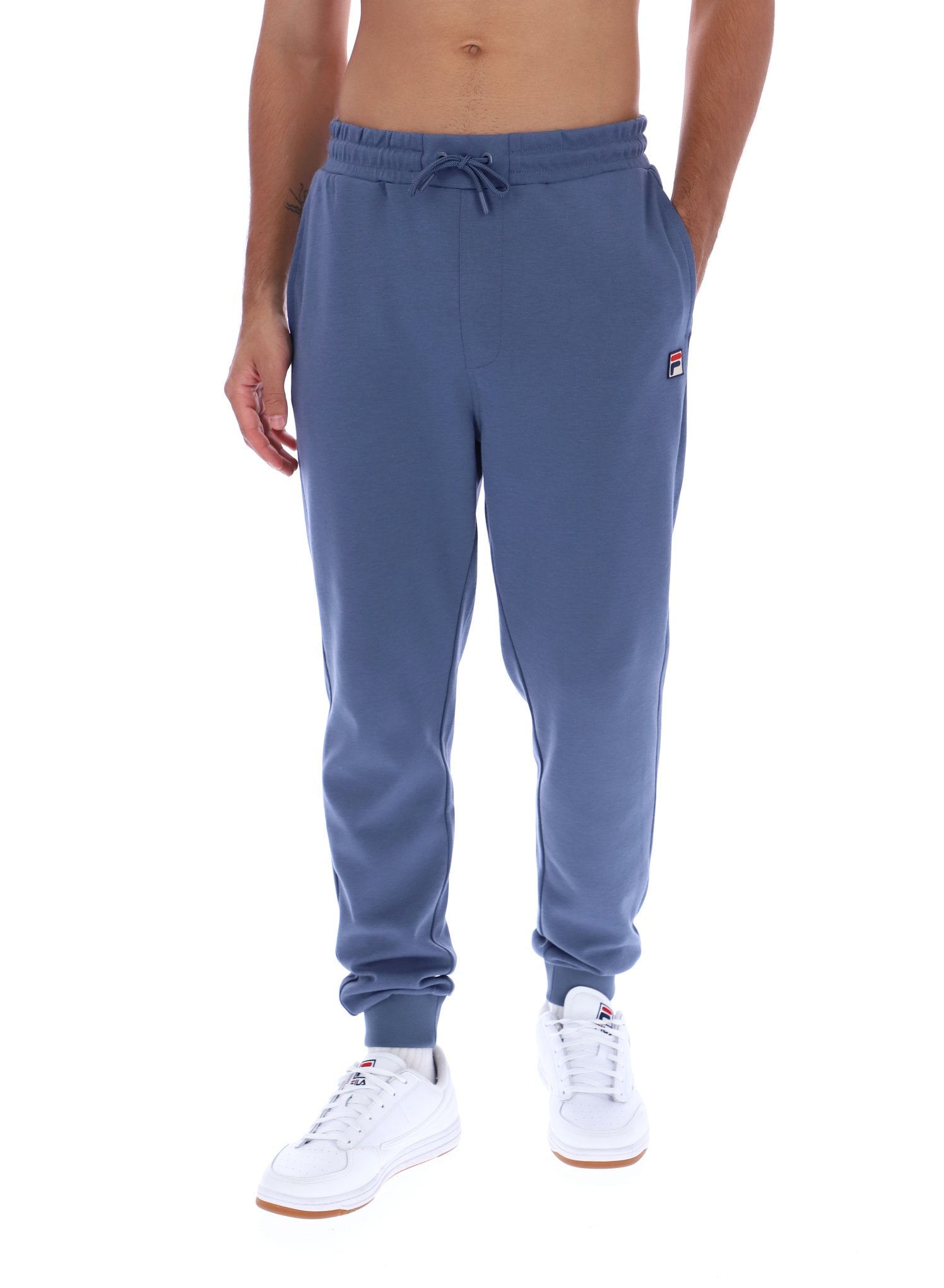 Blue sweatpants worn by a person on a white background