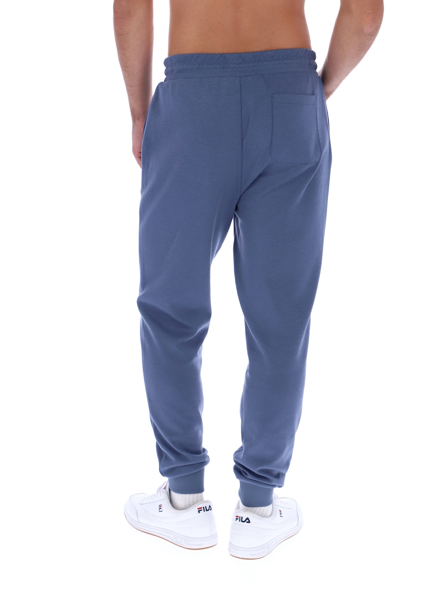 Blue sweatpants worn by a person on a white background