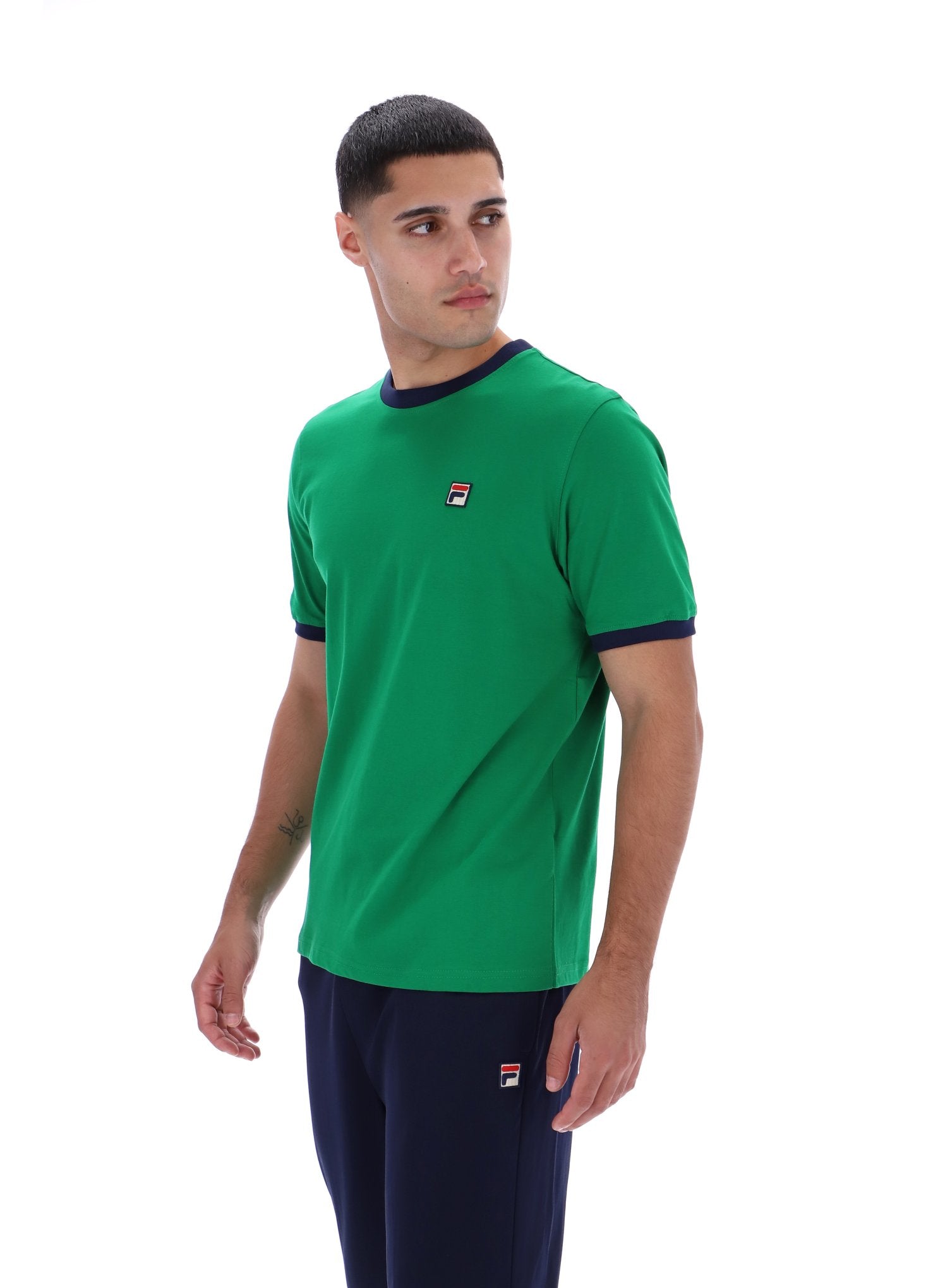 Man wearing a green t-shirt with a logo on a white background
