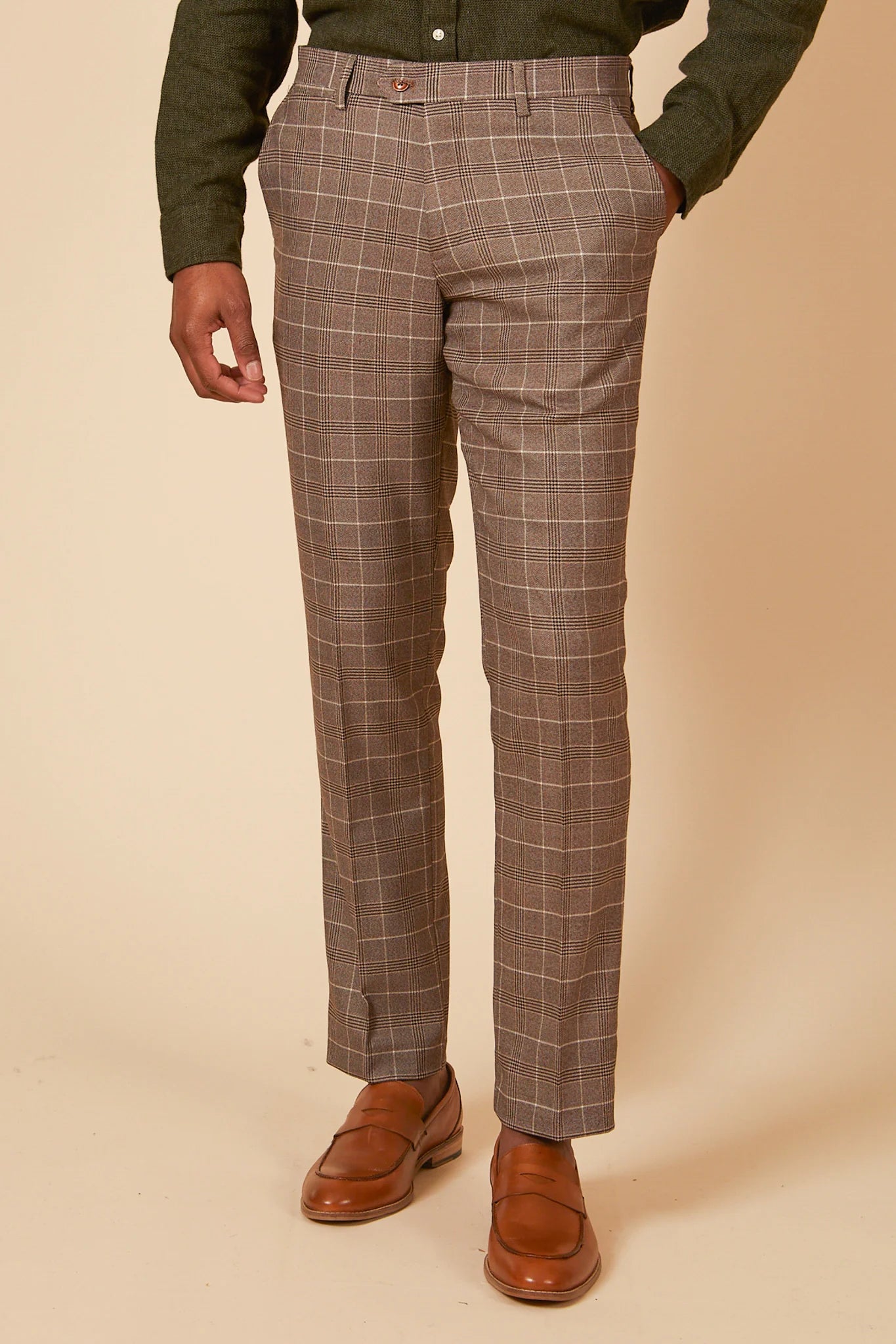 Brown checkered pants worn by a person on a beige background