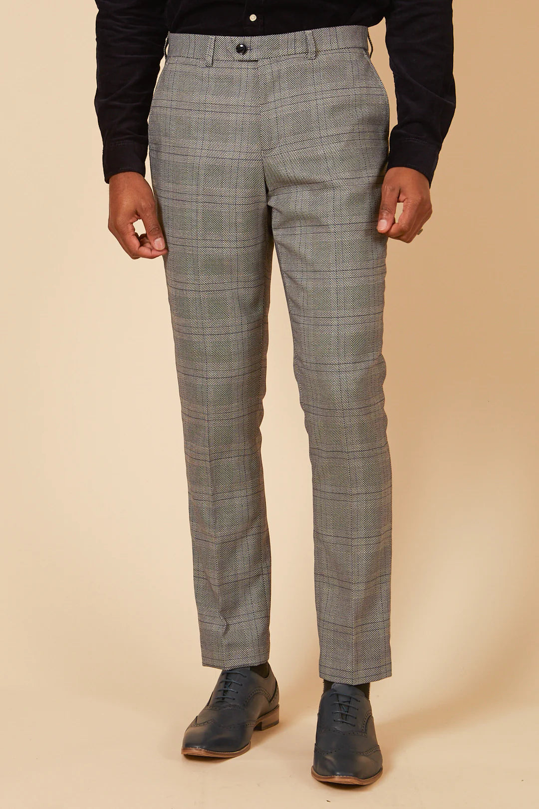 Gray checkered pants worn by a person on a beige background