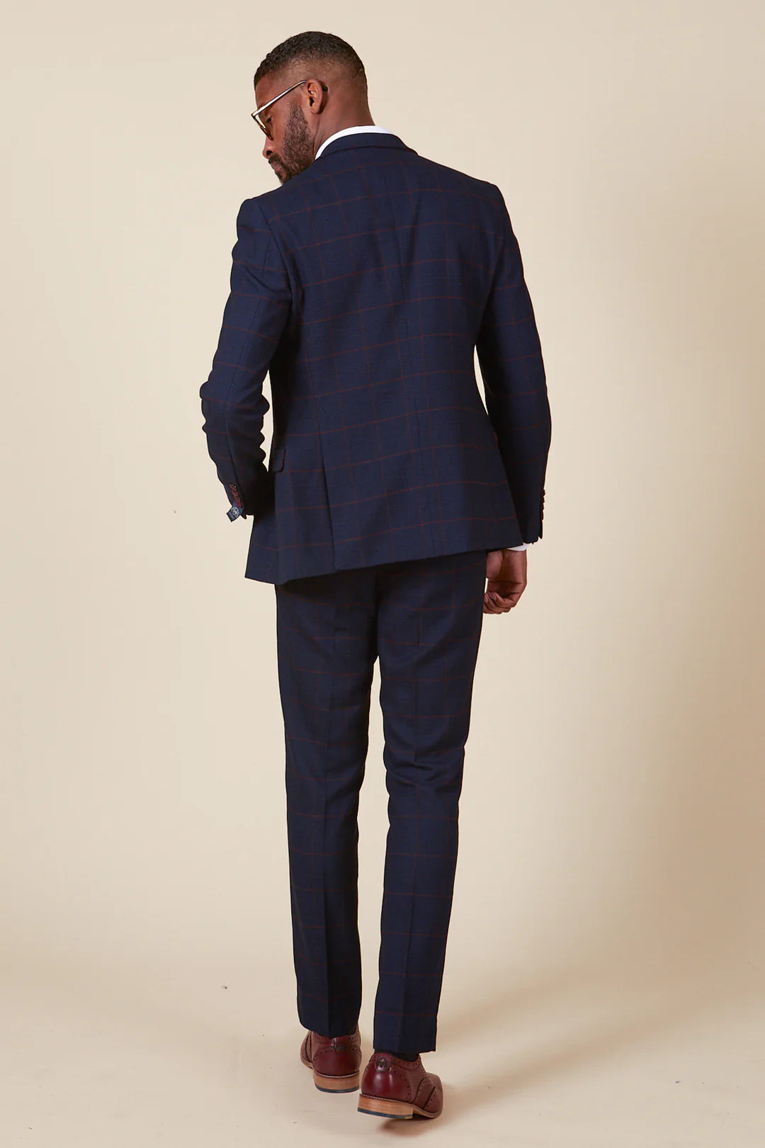 Man wearing a navy blue suit on a plain background