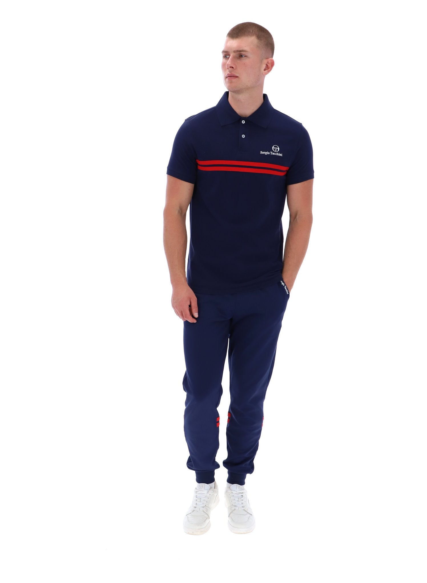 Man wearing a navy polo shirt with a red stripe and matching pants on a white background