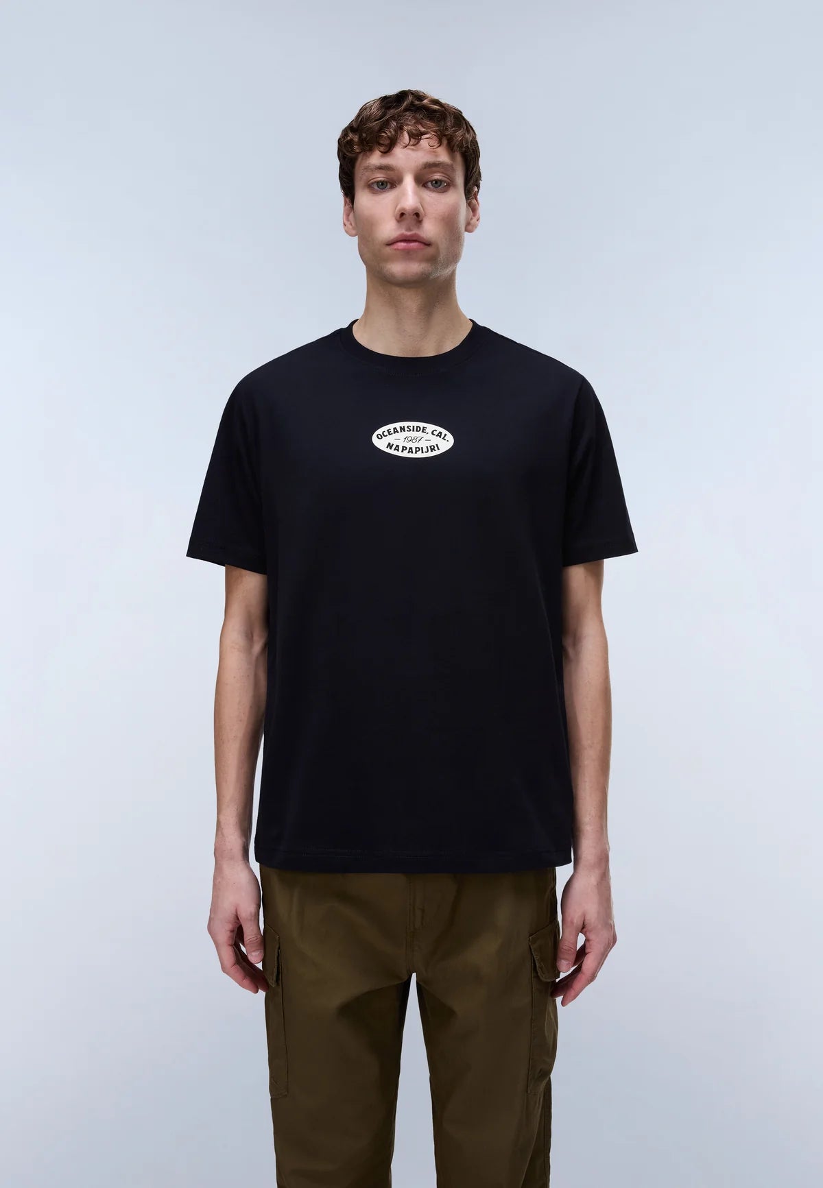Man wearing a black t-shirt with a logo on a light gray background