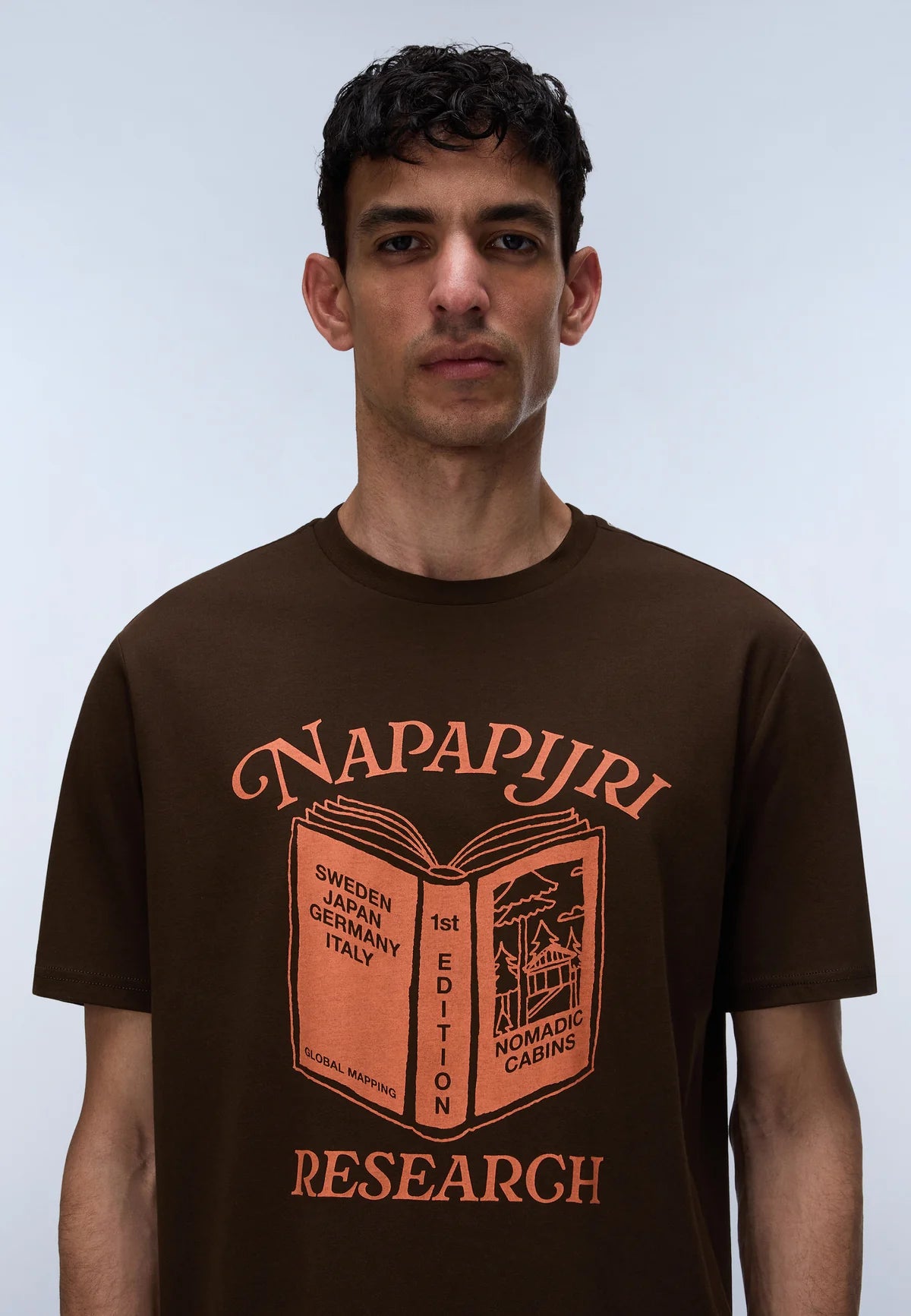 Man wearing a brown t-shirt with 'Napapijri' logo and text on a light blue background