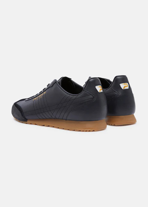 A pair of black Patrick Villan trainers with a lace-up front, rubber outsole, and gold signature logo.