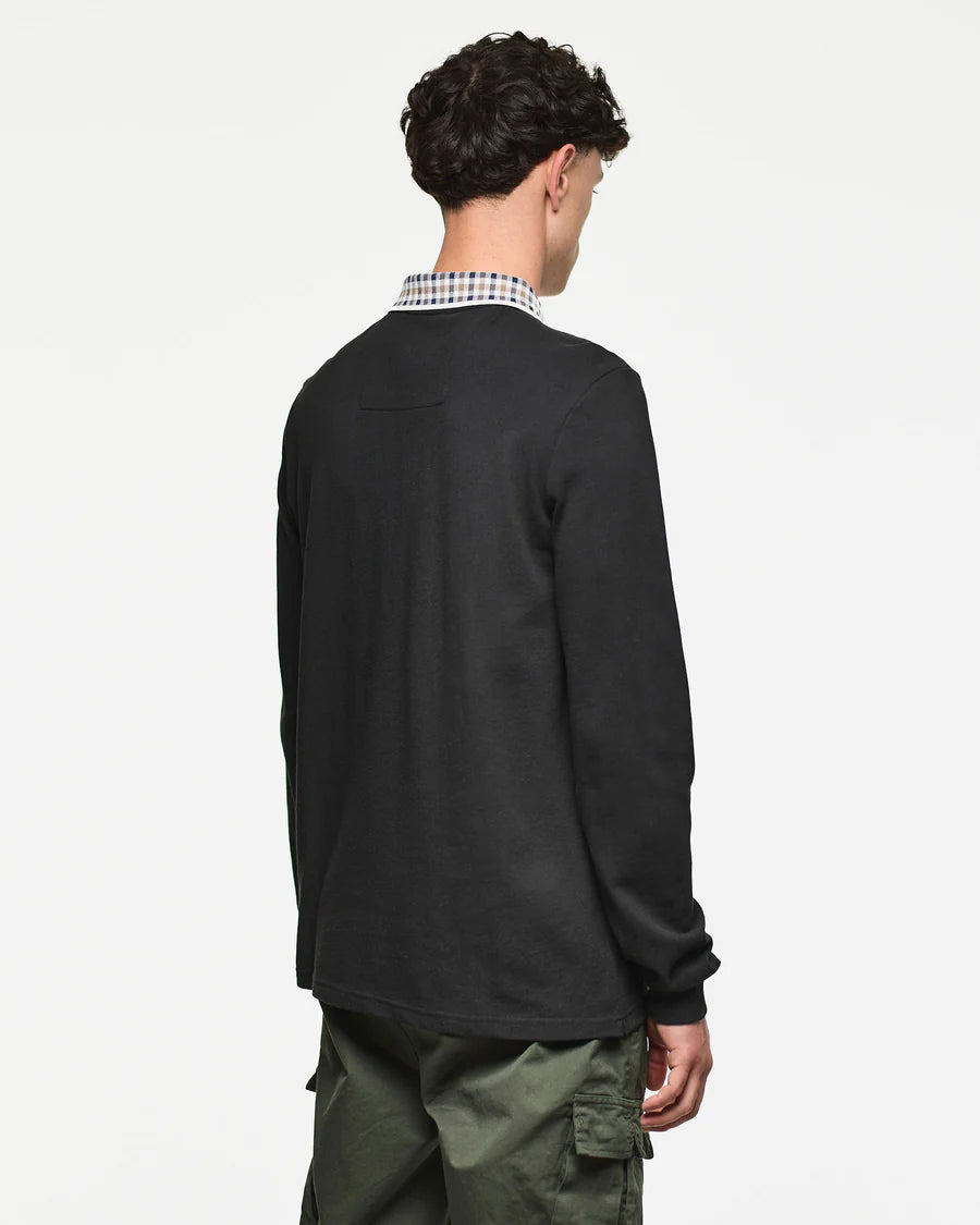 Person wearing a black long-sleeve shirt with a checkered collar on a white background