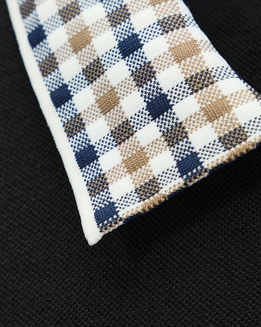 Close-up of a checkered fabric pocket square on a black background