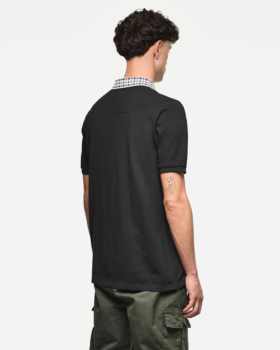 Person wearing a black polo shirt with a checkered collar on a white background