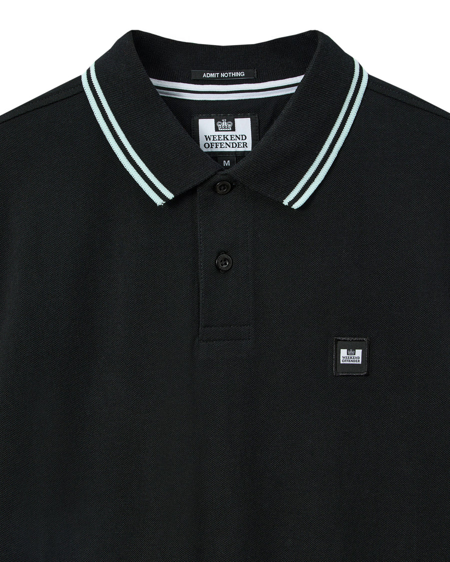 Black polo shirt with white trim collar and brand logo on a white background