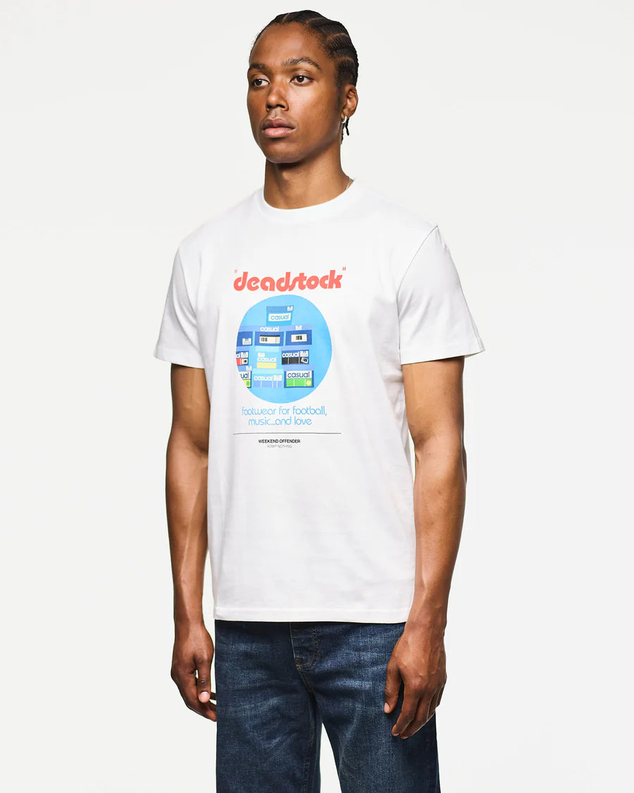 Person wearing a white t-shirt with 'deadstock' graphic design on a plain background