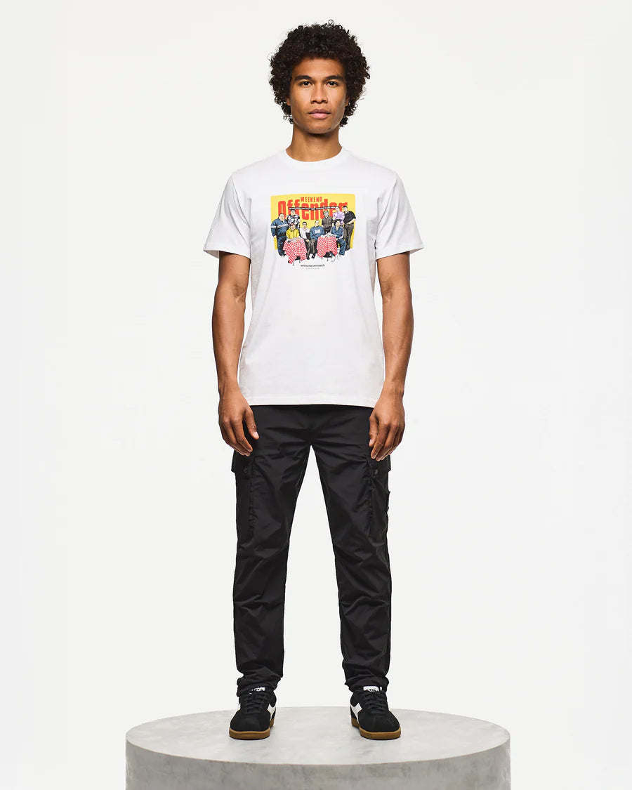 Person wearing a white t-shirt with a colorful graphic and black pants on a white background